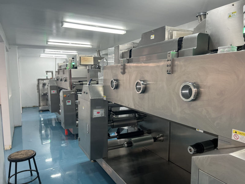 Industrial machine room with large industrial machines and a stool in the foreground.